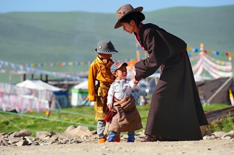 Paikalliset ihmiset, lapset ja äidit matkustavat Tiibetiin