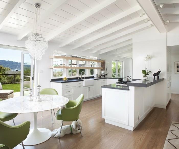 avoin keittiö, jossa valkoiset huonekalut ja vihreät aksentit