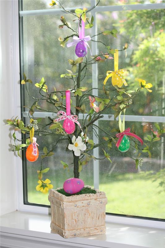 pääsiäiskoristekasvit koristavat värillisiä pääsiäismunia ikkunalaudan koristeluun