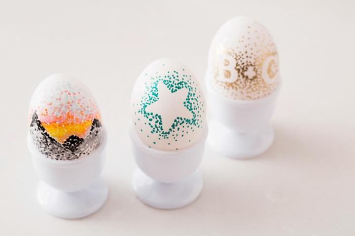 Pääsiäismunat maalaavat kirjaimet tähdet, jotka koristavat valkoisia munia