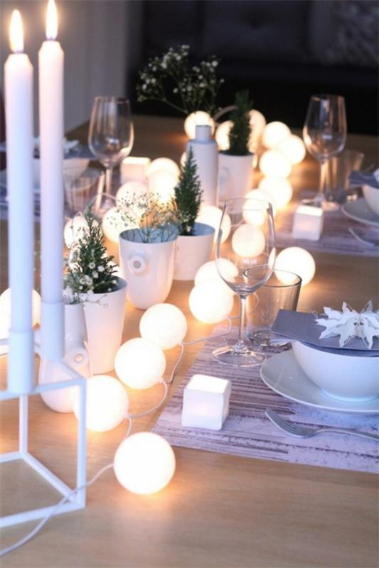 puristinen joulupöydän koristelu keijuilla ja valkoisilla kynttilöillä