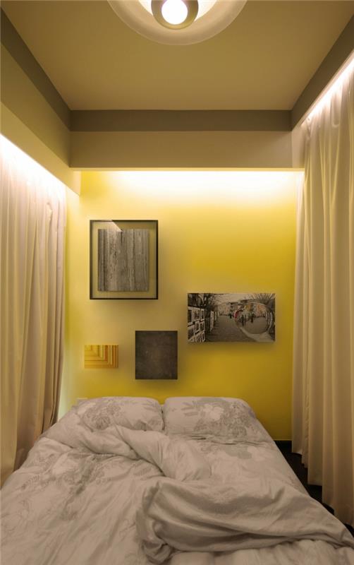 huonejakaja pieni huoneisto makuuhuone keltainen seinä pitkät verhot