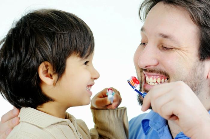asianmukainen hammashoito isä ja poika harjaavat hampaitaan