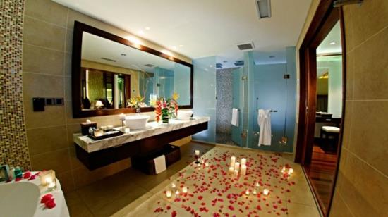 romanttiset kylpyhuoneen kynttilät ja kukka -terälehdet lattialla
