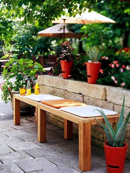 Varjoisa oleskelualue puutarhassa juo puisia penkityynyjä Varjoisa oleskelualue puutarhassa juo puupenkityynyjen värejä