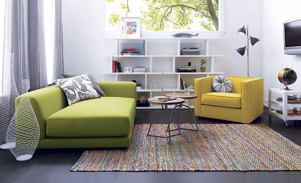 tyylikkäät vihreät huonekalut leveä sohva värikäs kudottu matto