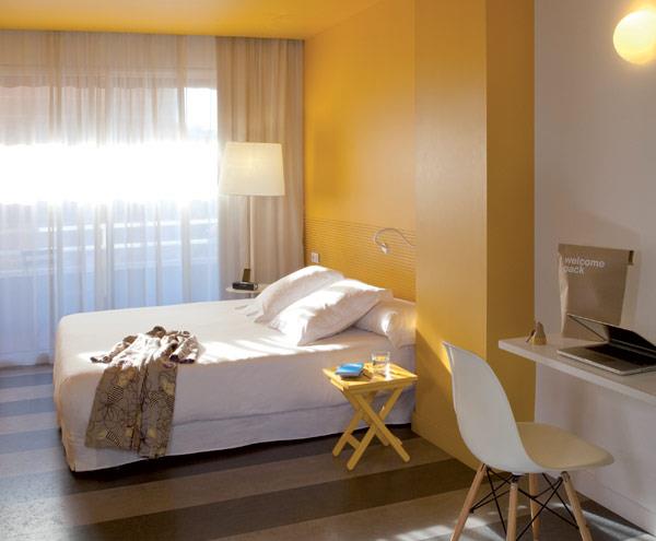 tyylikäs yksinkertainen hotelli espanja makuuhuone keltainen seinä
