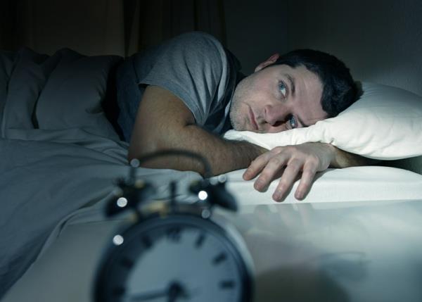 mies sängyssä silmät auki kärsii unettomuudesta unihäiriö