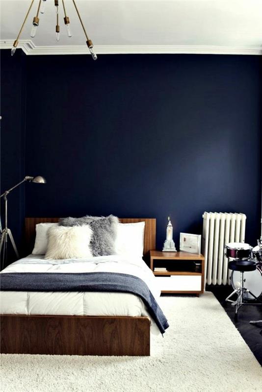 makuuhuoneen siniset tummansiniset seinät valkoinen matto puukalusteet