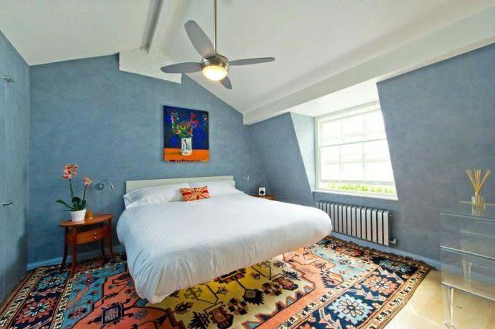 makuuhuoneen viisto katto, siniset seinät ja värillinen matto