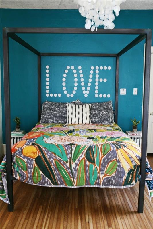 Kalusta makuuhuone värikkäillä liinavaatteilla ja sinisillä seinillä