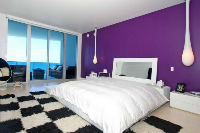 makuuhuoneen sisustus viileitä riippuvalaisimia mattokuvio musta valkoinen violetti aksenttiseinä