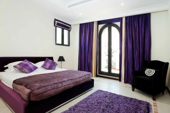 makuuhuoneen sisustus violetti aksentti nojatuolit vaaleat seinät parveke