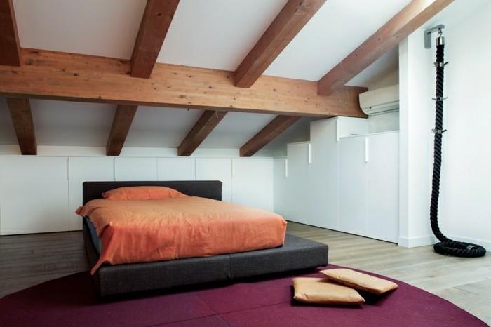 makuuhuoneen kalustus, jossa viisto katto lia matto ja puupalkit