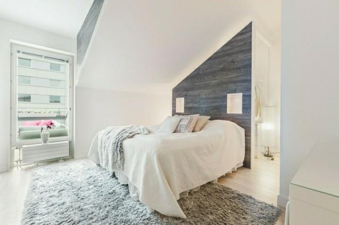 Kalusta makuuhuone kaltevalla katolla ja harmaalla aksenttiseinällä ja vaaleanharmaalla matolla