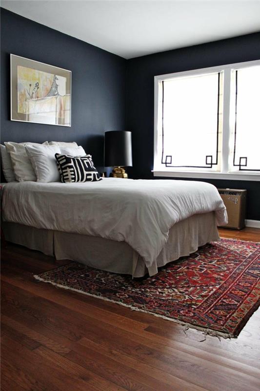 makuuhuoneen harmaat sävyt tumman värinen matto vaaleat vuodevaatteet