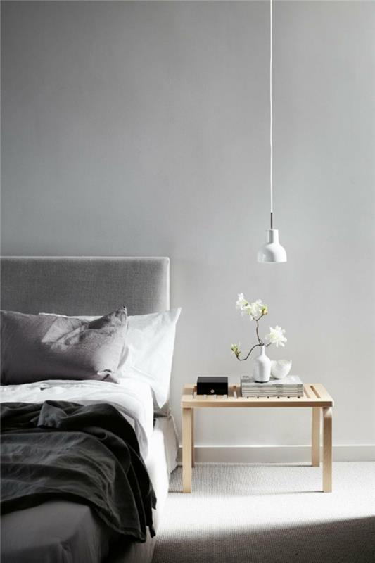 makuuhuone harmaa vaaleat seinät minimalistinen sisustus kukkia