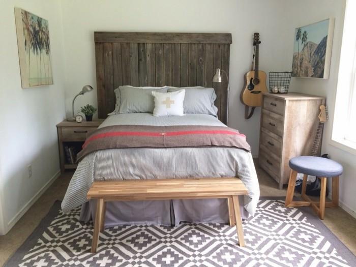 makuuhuoneen maalaistyylinen geometrinen matto ja maalaismainen sängynpääty