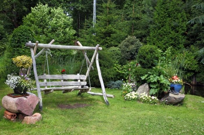 kaunis puutarha, jossa on keinut ja kivet sivupöydiksi