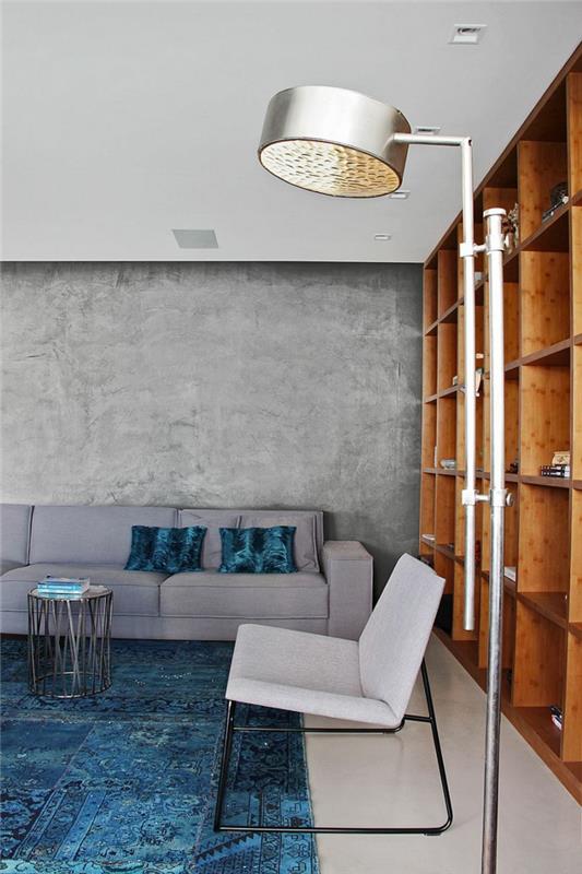 kauniita eläviä ideoita olohuone sisustus betoniseinät sininen matto hyllyjärjestelmä