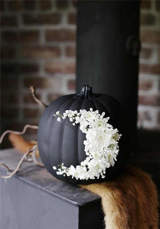 musta kurpitsa valkoisilla kukilla koristamaan halloweenia
