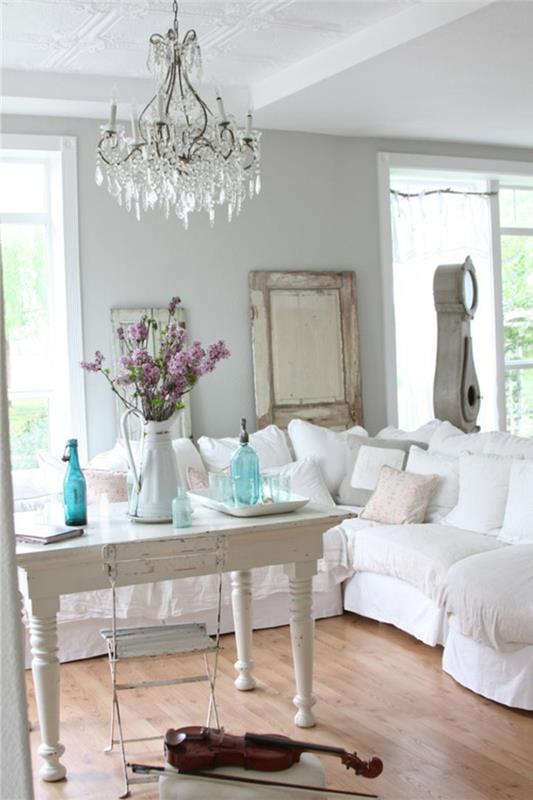 nuhjuinen tyylikäs olohuone valkoinen kulmasohva puuta korostavat pöytäkoristeet kukat