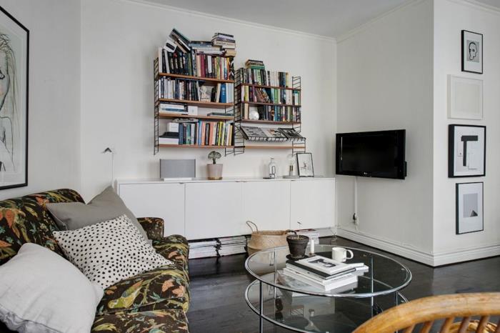 Skandinaavinen elävä pieni huoneisto kirjahyllyt valkoinen pukeutuja pyöreä sohvapöytä