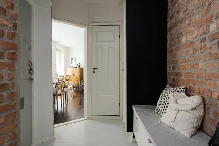 Skandinaavinen elävä pieni huoneisto, jossa on tiiliseinäinen penkki -eteinen