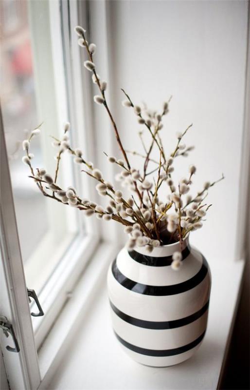 Skandinavian kevätkoriste maljakko kukkivista oksista ikkunan päällä