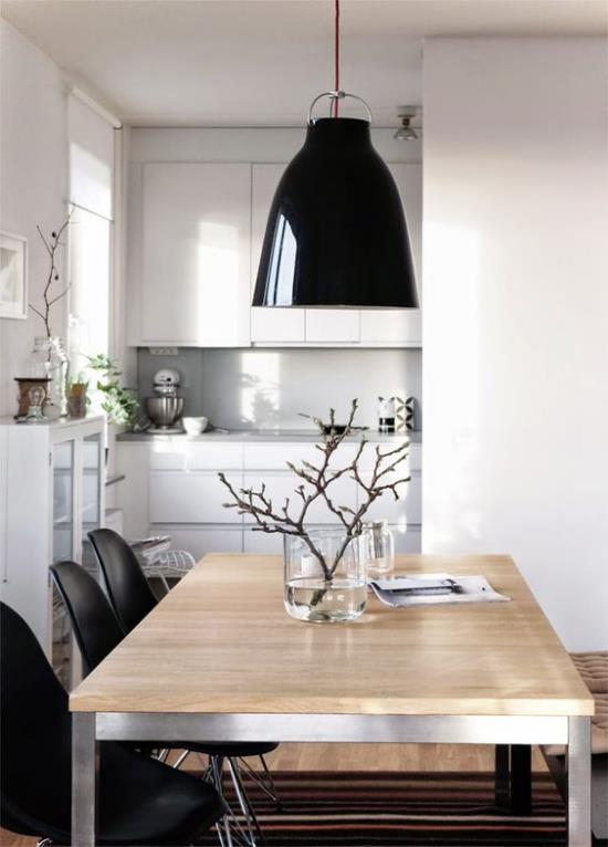 Skandinaavinen kevätkoriste moderni keittiö riippuvalaisimet vaalea puu maljakko kukkivilla oksilla