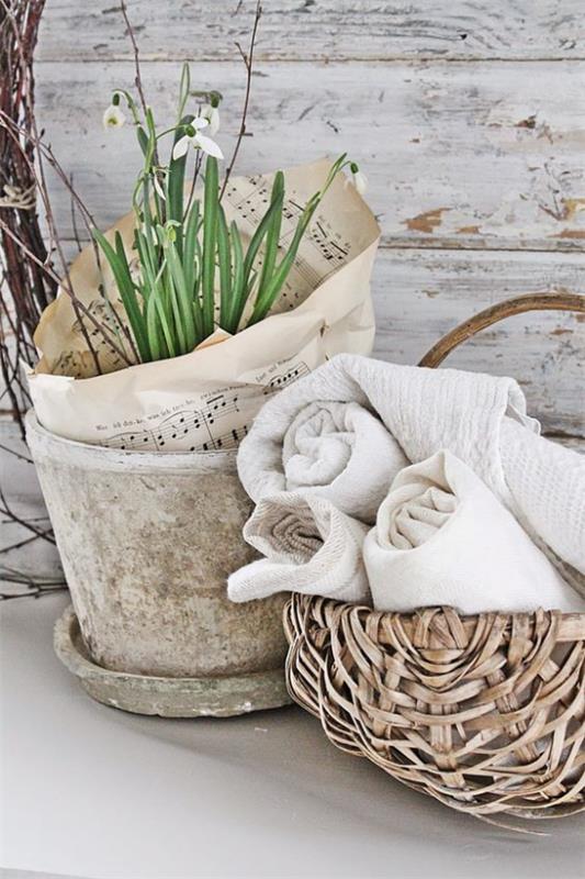 Skandinaavinen kevätkoriste maalaismainen järjestely vanha kukkaruukku valkoinen lumikellokori pyyhkeillä