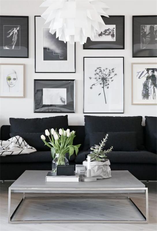 Skandinaavinen kevätkoriste kaunis olohuone tyylikäs huonekalutaulu musta sohva matala pöytä valkoinen tulppaanit