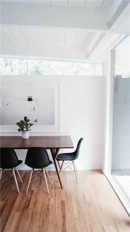Skandinaavisia design -huonekaluesimerkkejä ruokapöytä ja Eames -tuolit musta