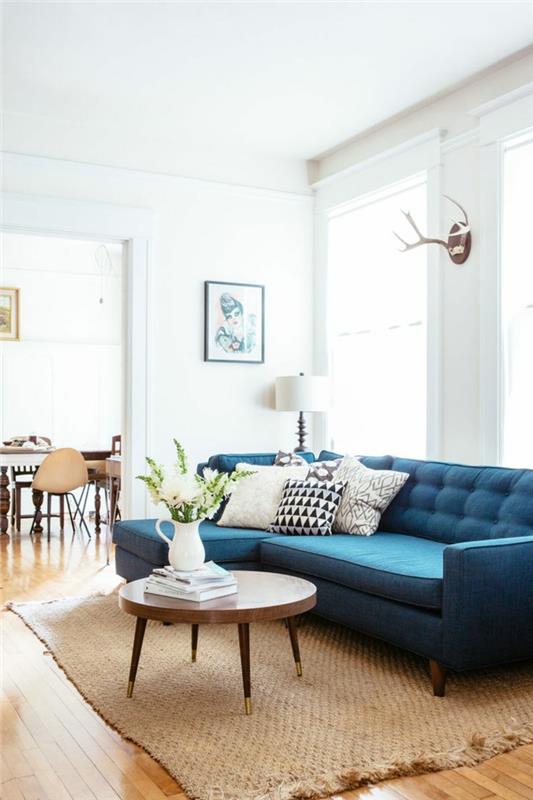 sohva sininen sisalmatto valkoiset seinät pyöreä sohvapöytä