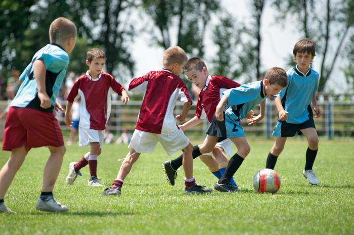 urheilu lapsille pojille, jotka pelaavat jalkapalloa