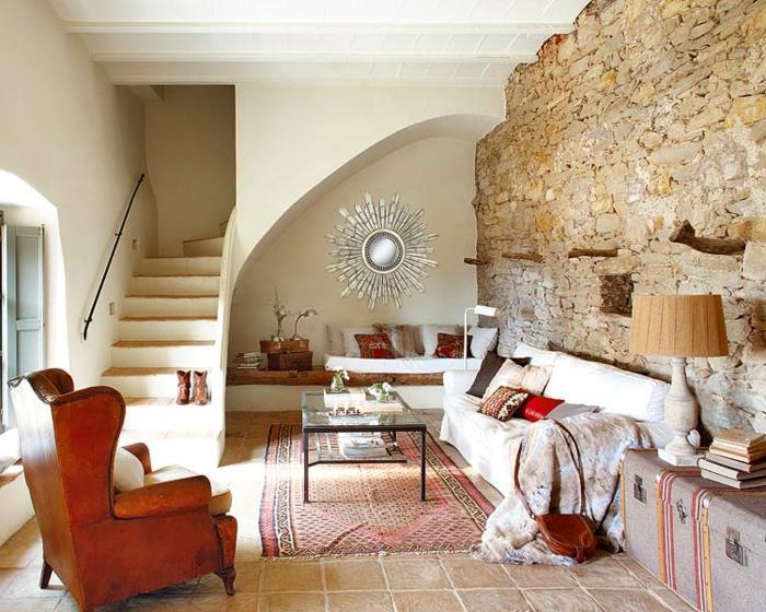 kiviseinä olohuone maalaismainen matto vintage nojatuolit sisäportaat