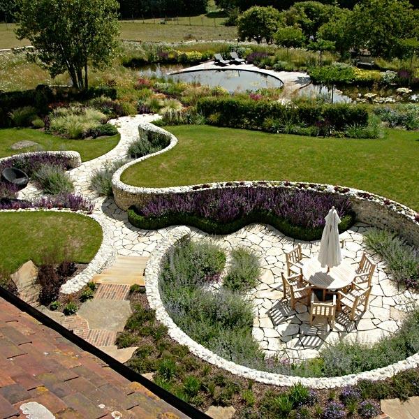 sussex puutarha nurmikko pyöreä pöytä puiset tuolit lampi