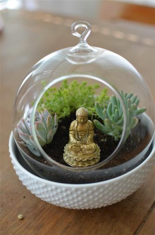 terrarium istuttaa lasiastiat pyöreän buddha -patsaan ympärille