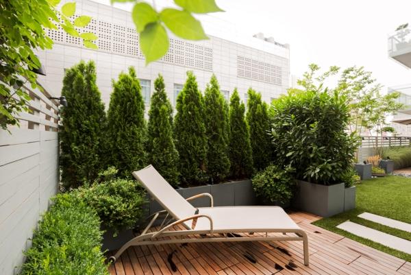 terassi yksityisyysnäyttö puinen veranta ikivihreät kasvit yksityisyysnäytöinä