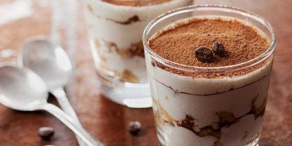 tiramisu lasissa, jossa on kaakaojauhetta ja kahvipapuja