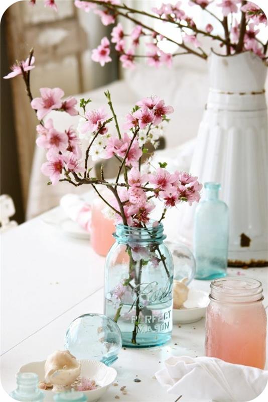 pöydän koristelu häät kevätkoriste kukkivat oksat muurauspurkit
