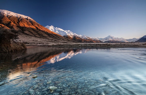 Téli napfelkelte a Tasman -folyón áttekintve Aoraki / Mt Cook felé, hóval borítva, Mackenzie Country, Canterbury, Új -Zéland - stock kép