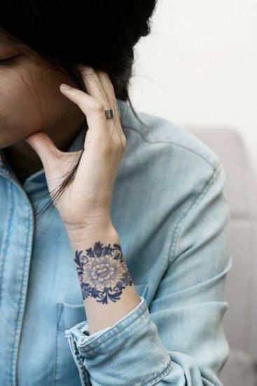 Små blomsterdesignede tatoveringer på håndleddet