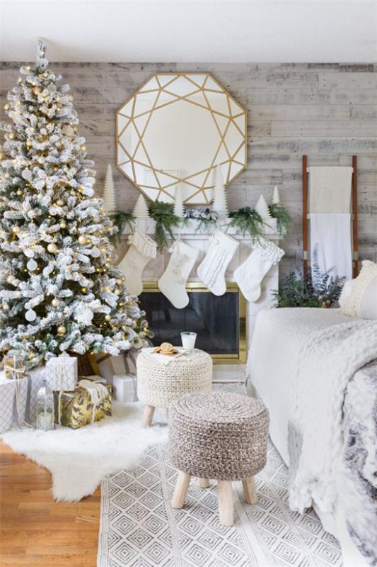 unenomainen joulukoriste olohuoneessa valkoinen koristelu valkoiset joulupukin saappaat pyöreä peili takan päällä