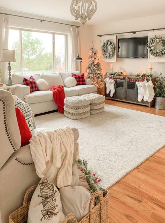 unenomainen joulukoriste olohuoneen leveässä huoneessa valkoisella ja vaalealla beigellä koristeltu joulukuusi vasemmalla punaisella aksentilla