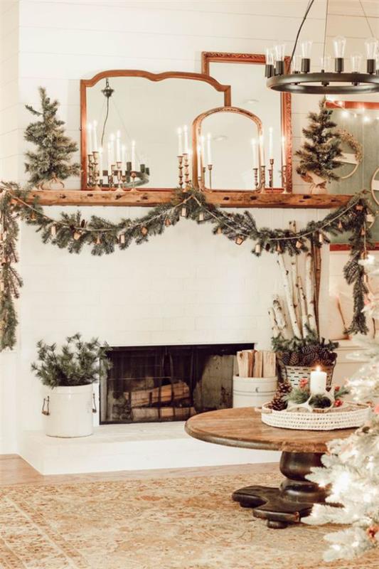 unenomaiset joulukoristeet olohuoneessa kaksi pientä kuusia takan ääressä kuusen vihreä seppele kodikas ja lämmin