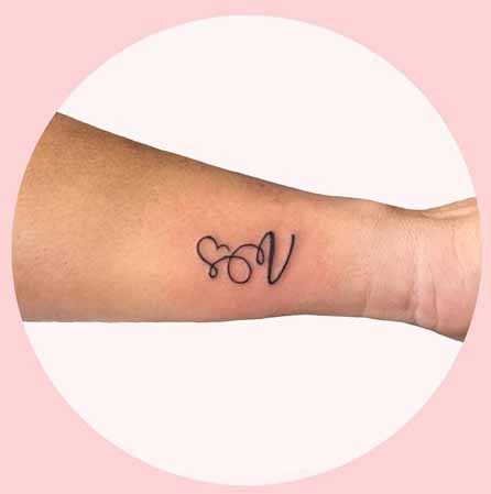 Gömbölyű V betű tetoválás tervezés a kéz
