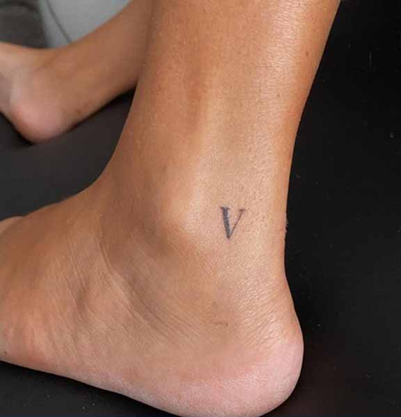 Aranyos V betűs tetoválás a bokán