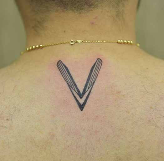Mágneses V szó tetoválás a hátán