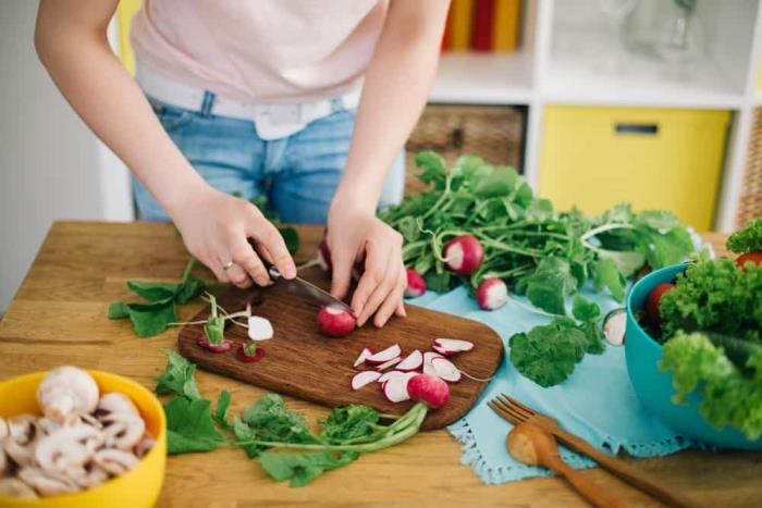 suojaa koronavirukselta tuoreita vihanneksia salaatin valmistuksessa keittiössä